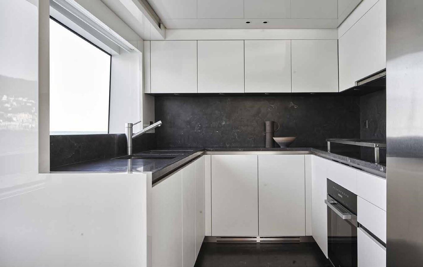 a kitchen with white cabinets aboard OMNIA Yacht for Sale
