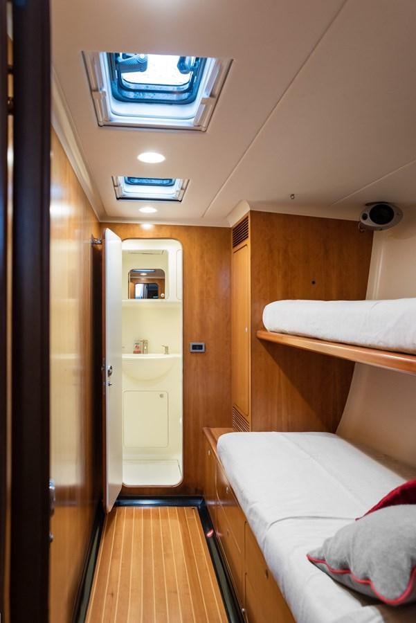 a room with a bed and a shelf with a bookcase aboard MISTER A Yacht for Sale