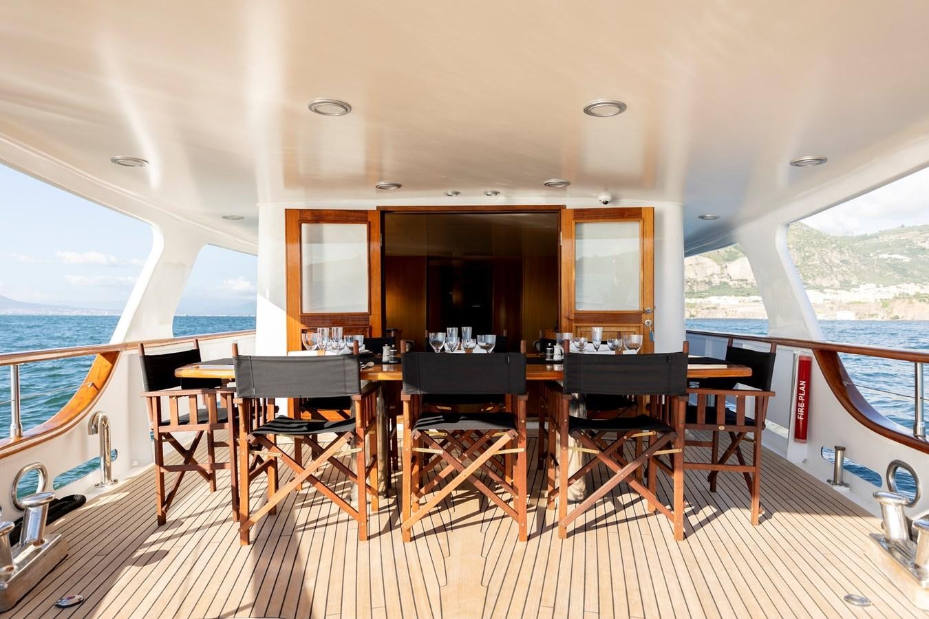 a deck with a table and chairs on it aboard SOUNION II Yacht for Sale