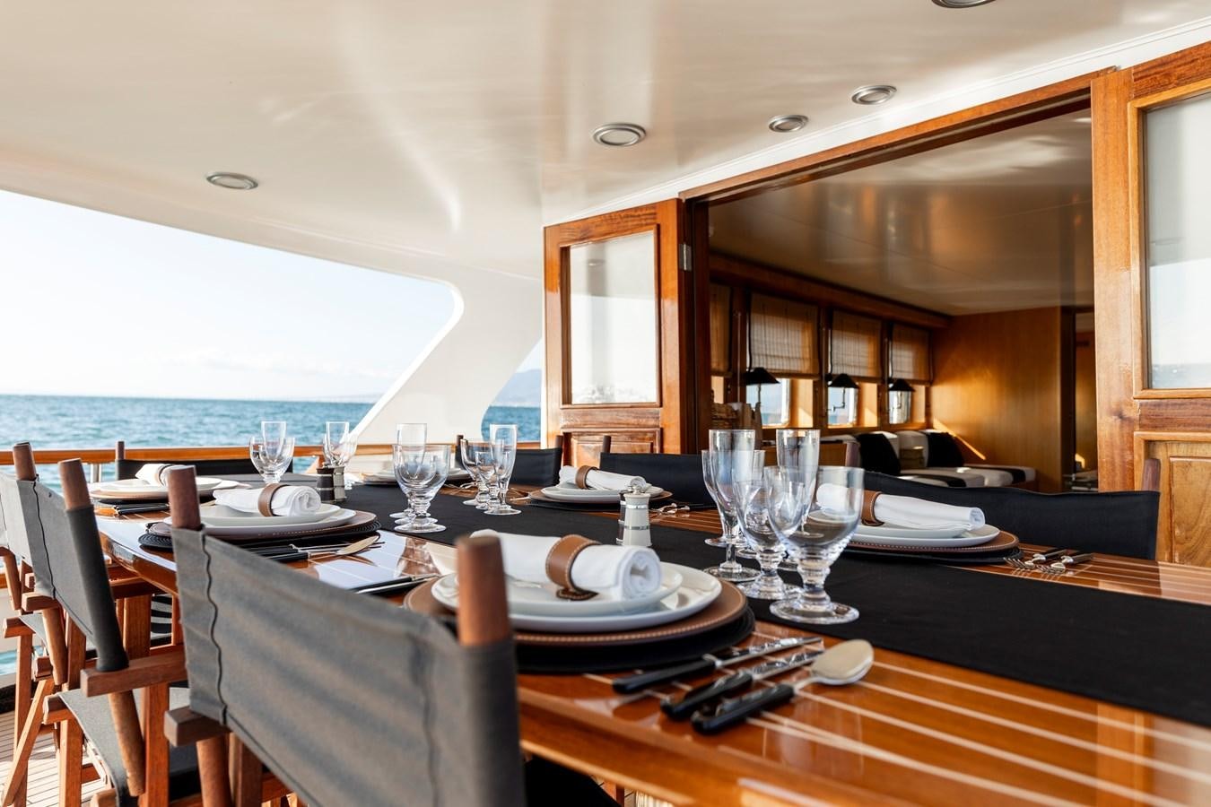 a dining table with plates and glasses aboard SOUNION II Yacht for Sale
