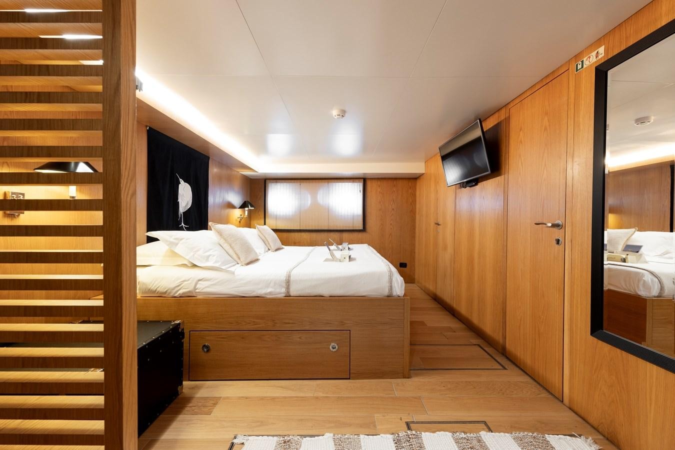 a room with a bed and a television aboard SOUNION II Yacht for Sale