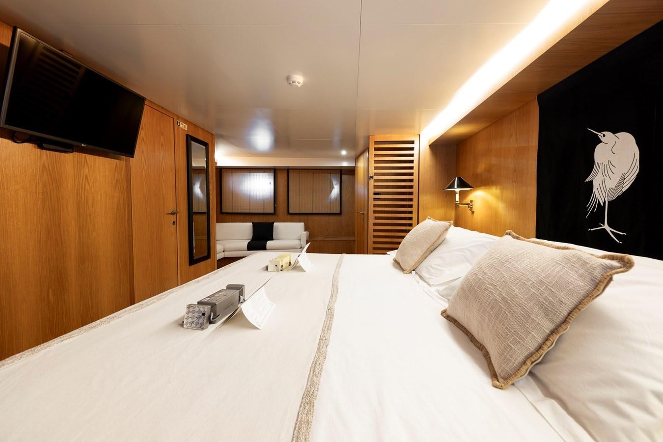 a bed with a white sheet and a black wall aboard SOUNION II Yacht for Sale