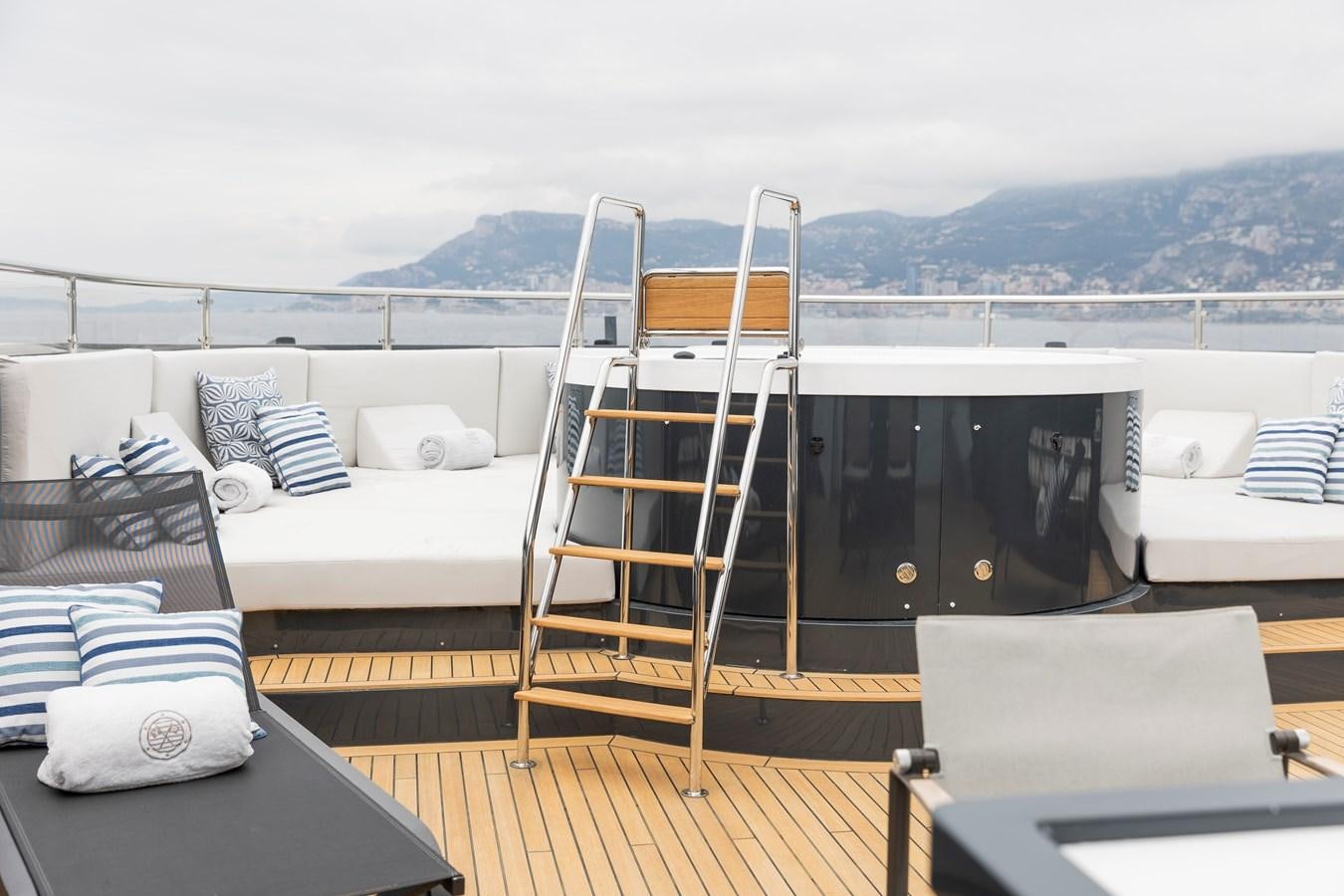 a balcony with a bed and a table and chairs aboard OCEAN PEARL - FRACTIONAL OWNERSHIP VESSEL Yacht for Sale
