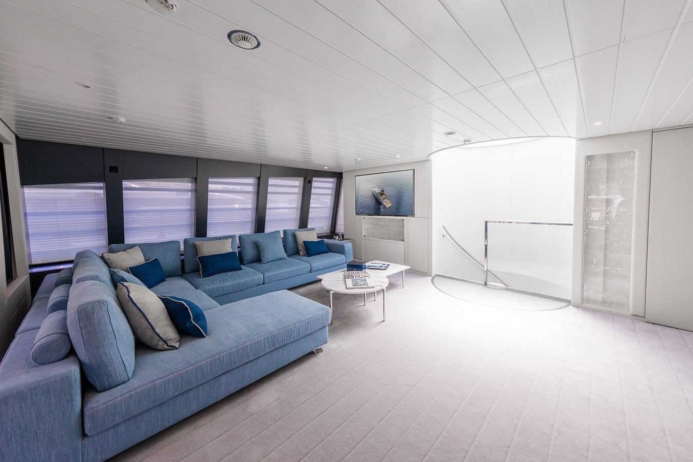 a living room with a blue couch aboard OCEAN PEARL - FRACTIONAL OWNERSHIP VESSEL Yacht for Sale