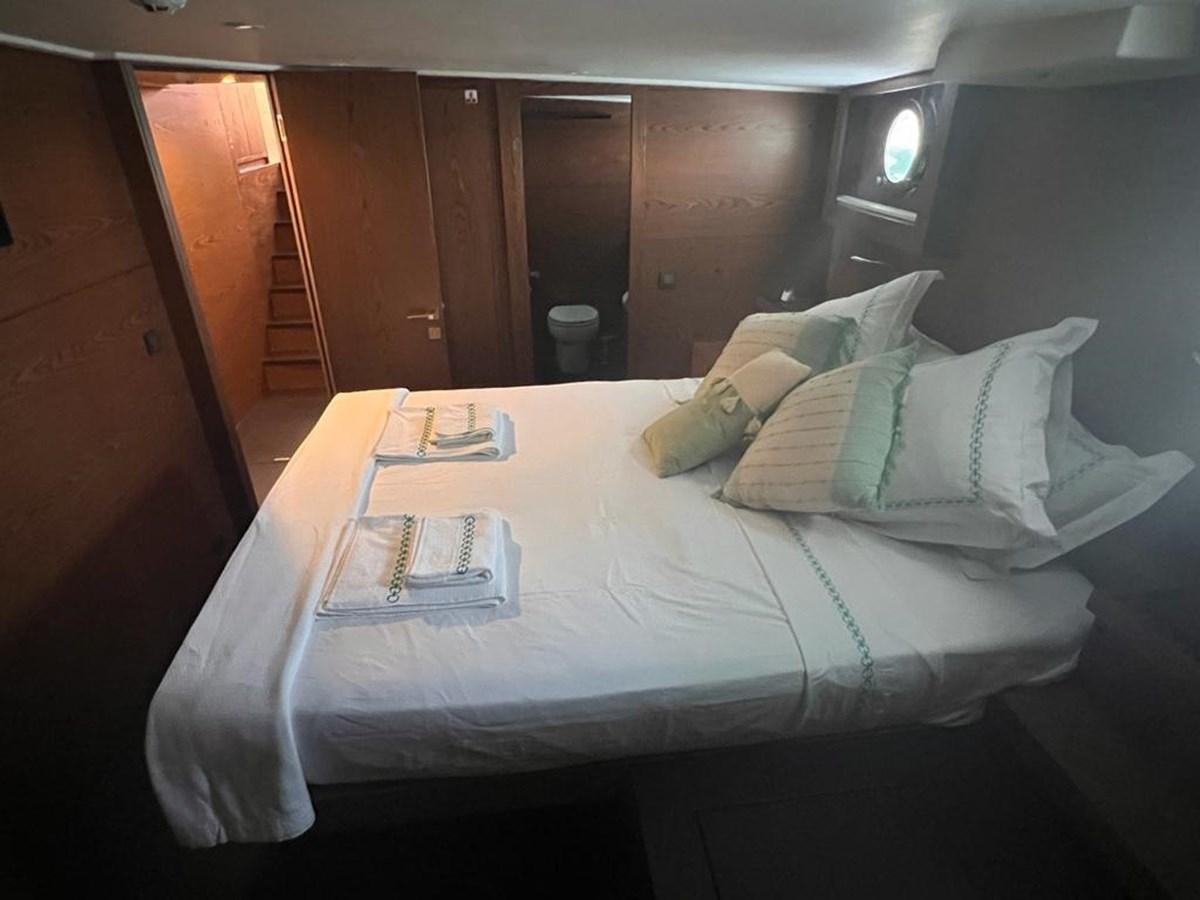 a bed with a white sheet and a white pillow aboard AYO Yacht for Sale