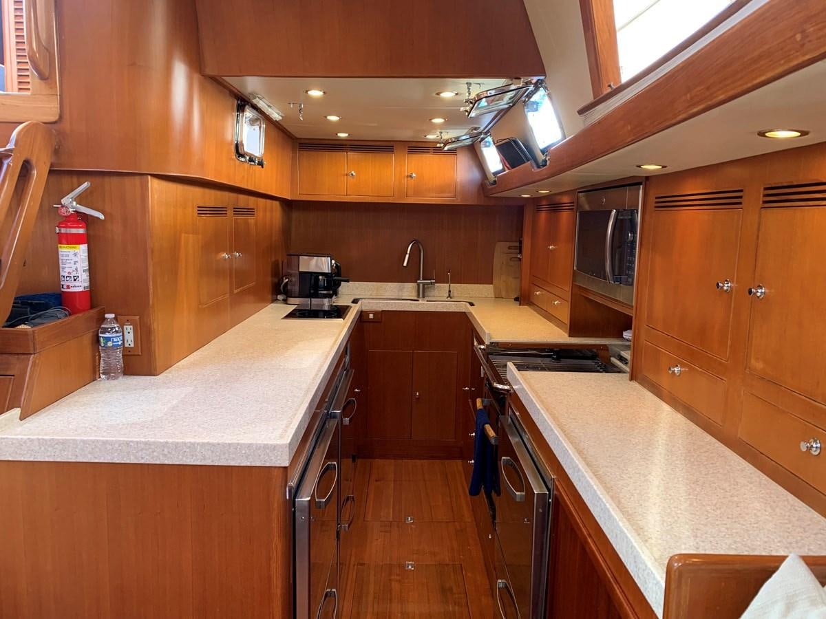 a kitchen with wooden cabinets aboard LUCKY B Yacht for Sale