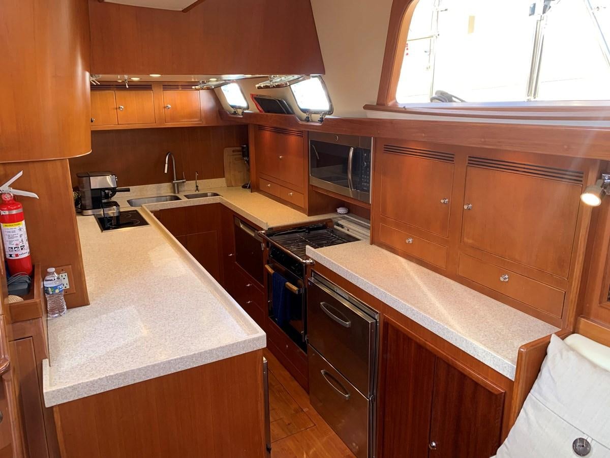 a kitchen with wooden cabinets aboard LUCKY B Yacht for Sale
