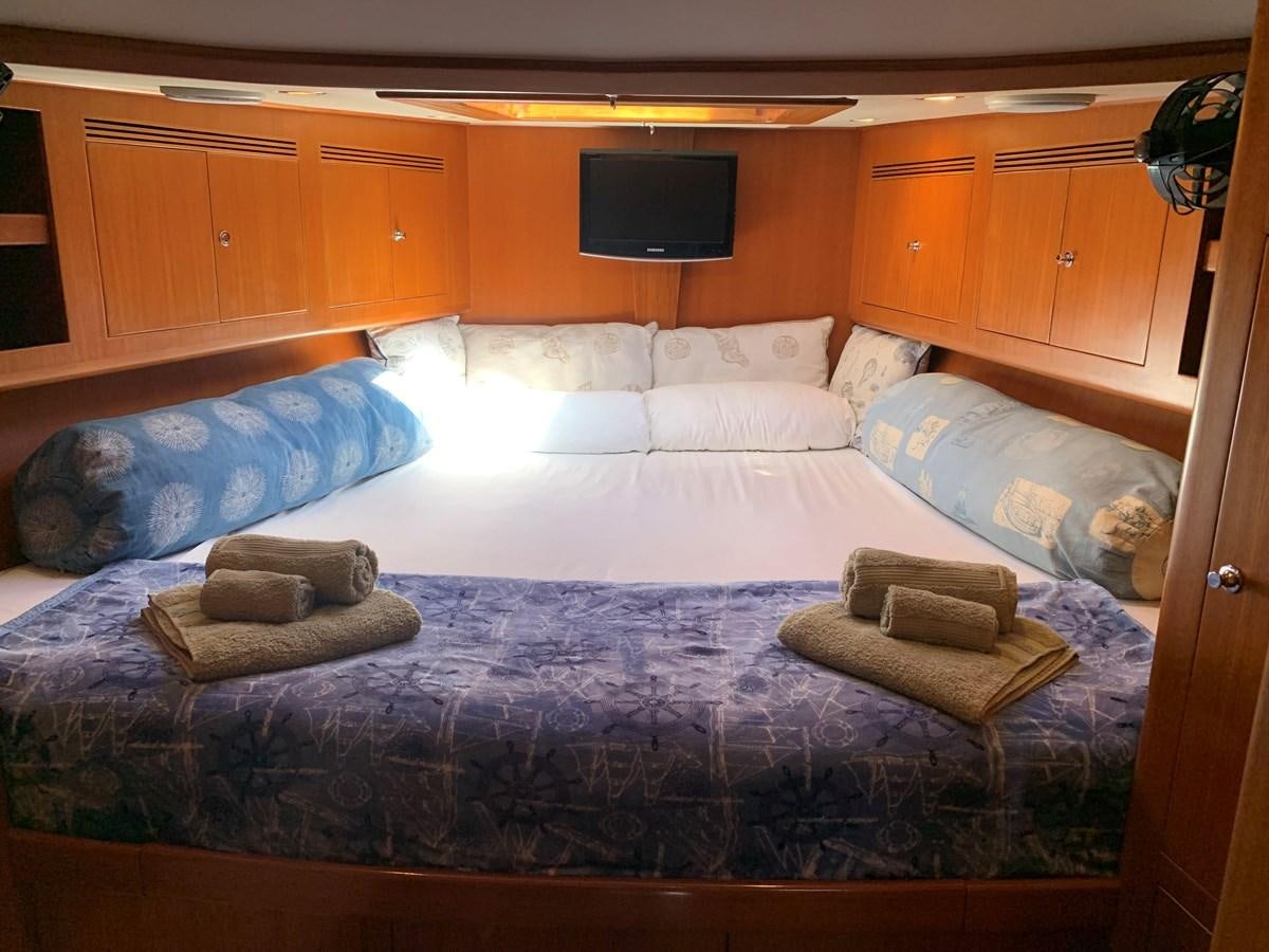 a bed with a blue comforter aboard LUCKY B Yacht for Sale