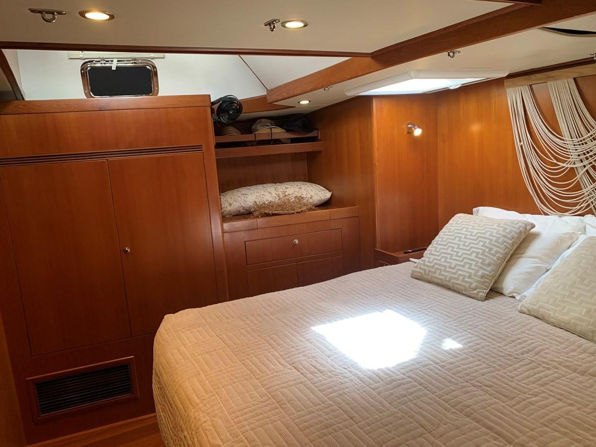 a bed with a white sheet aboard LUCKY B Yacht for Sale
