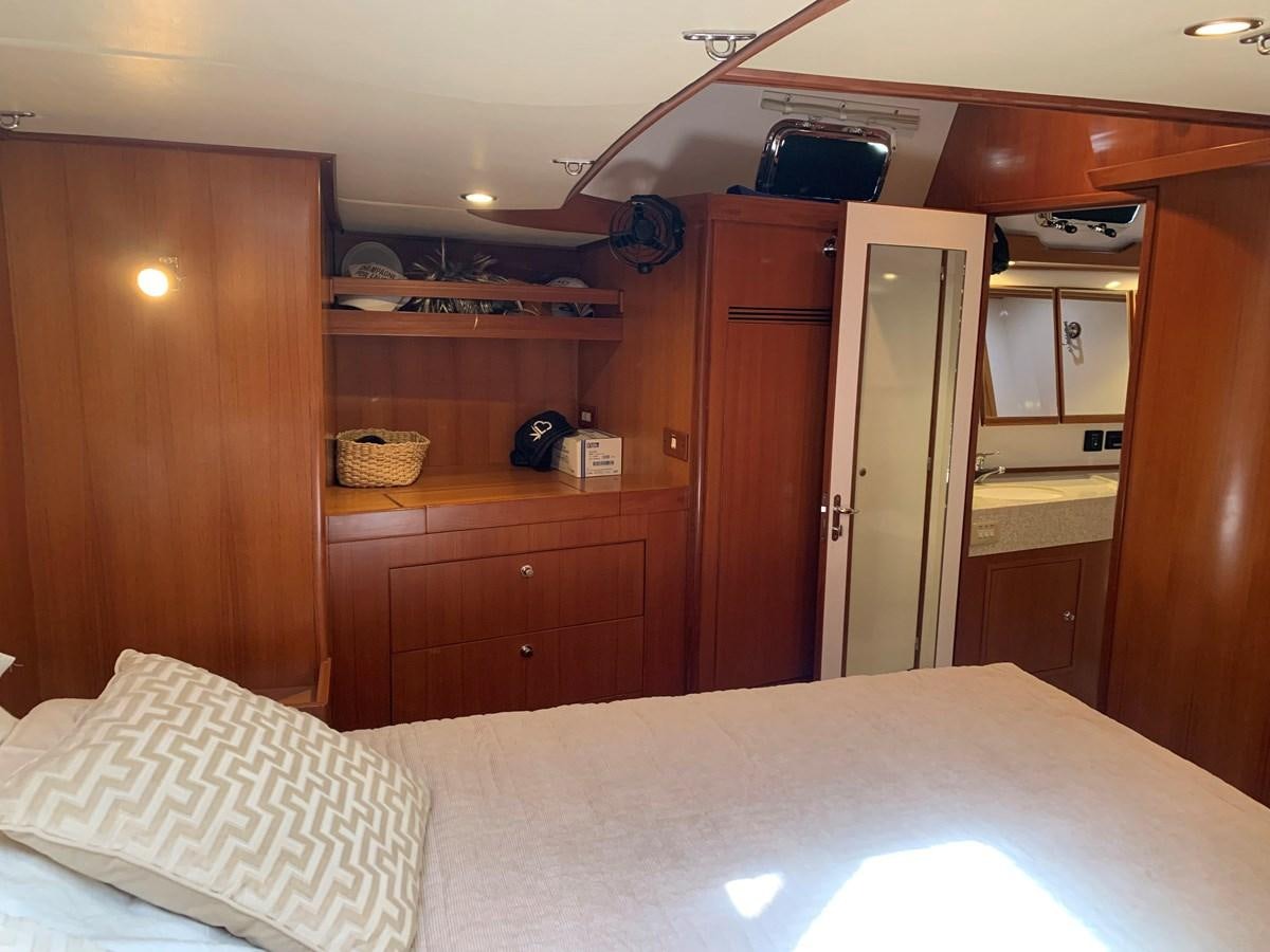 a bedroom with a bed and a desk aboard LUCKY B Yacht for Sale