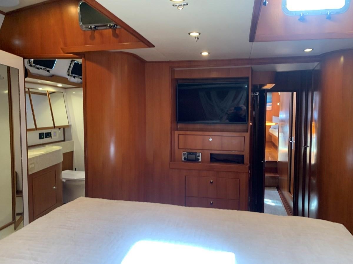 a room with a bed and a television aboard LUCKY B Yacht for Sale
