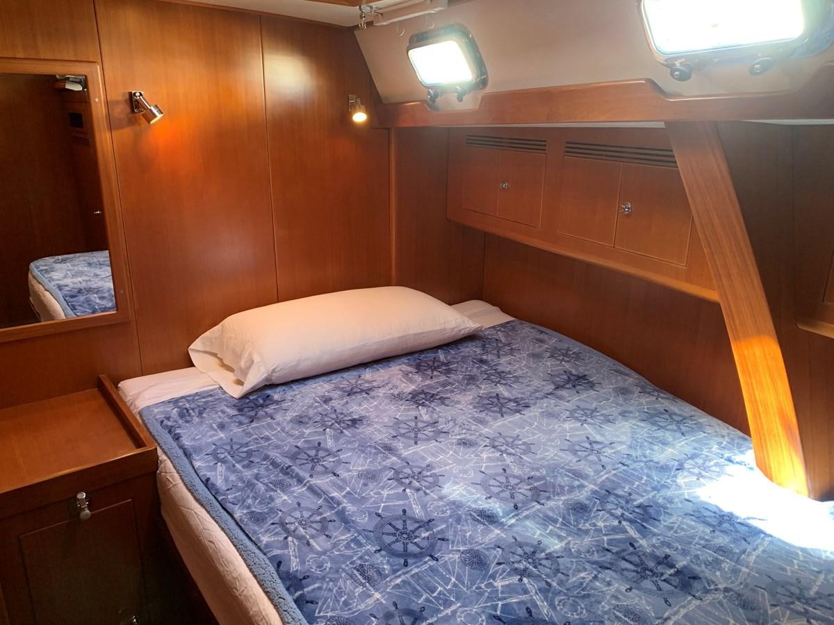 a bed with a wooden headboard aboard LUCKY B Yacht for Sale