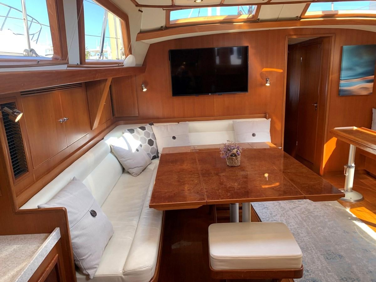 a room with a couch and a television aboard LUCKY B Yacht for Sale