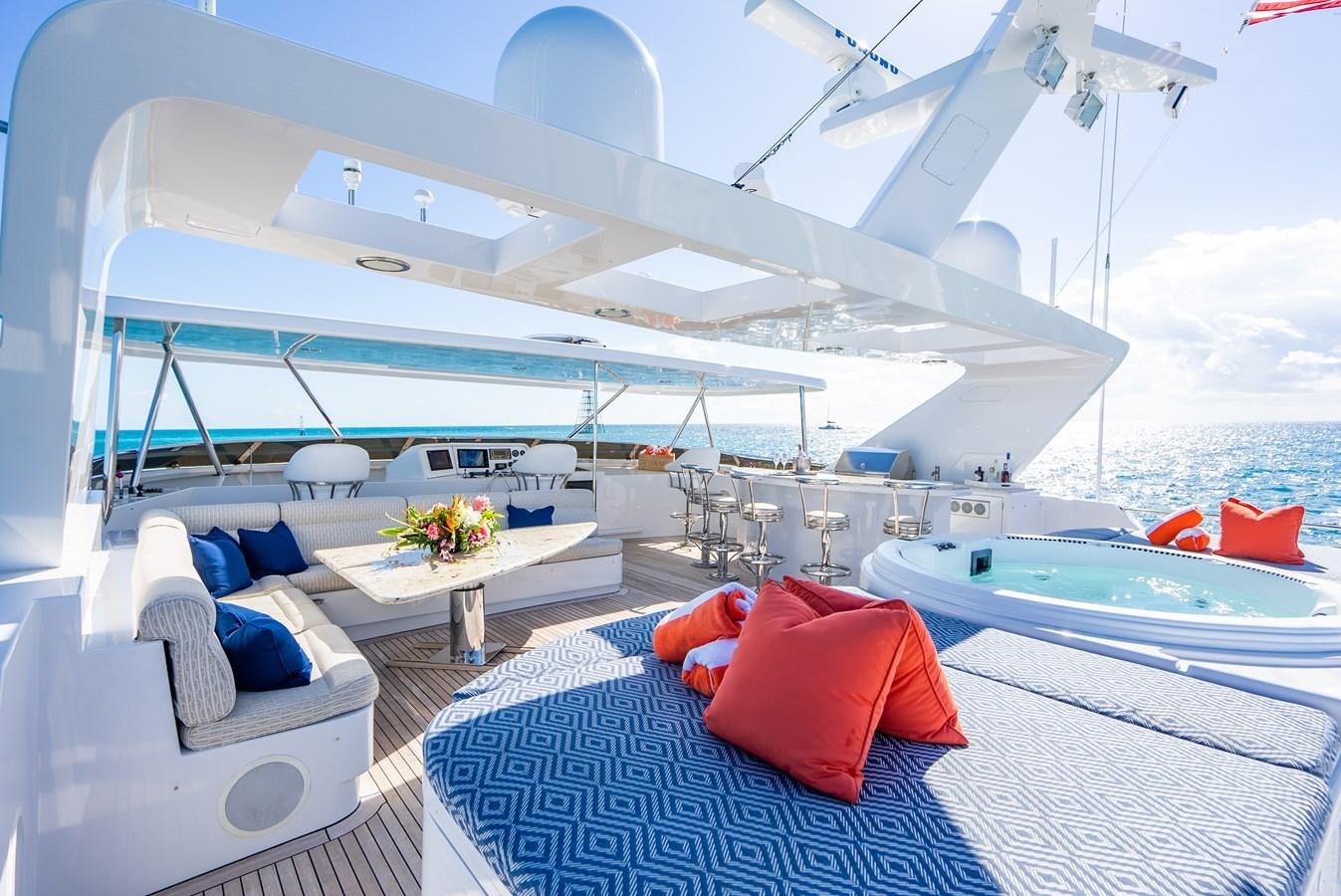 a large white boat with a red pillow on a blue and white striped bed and white pillows on aboard SEAQUEST Yacht for Sale