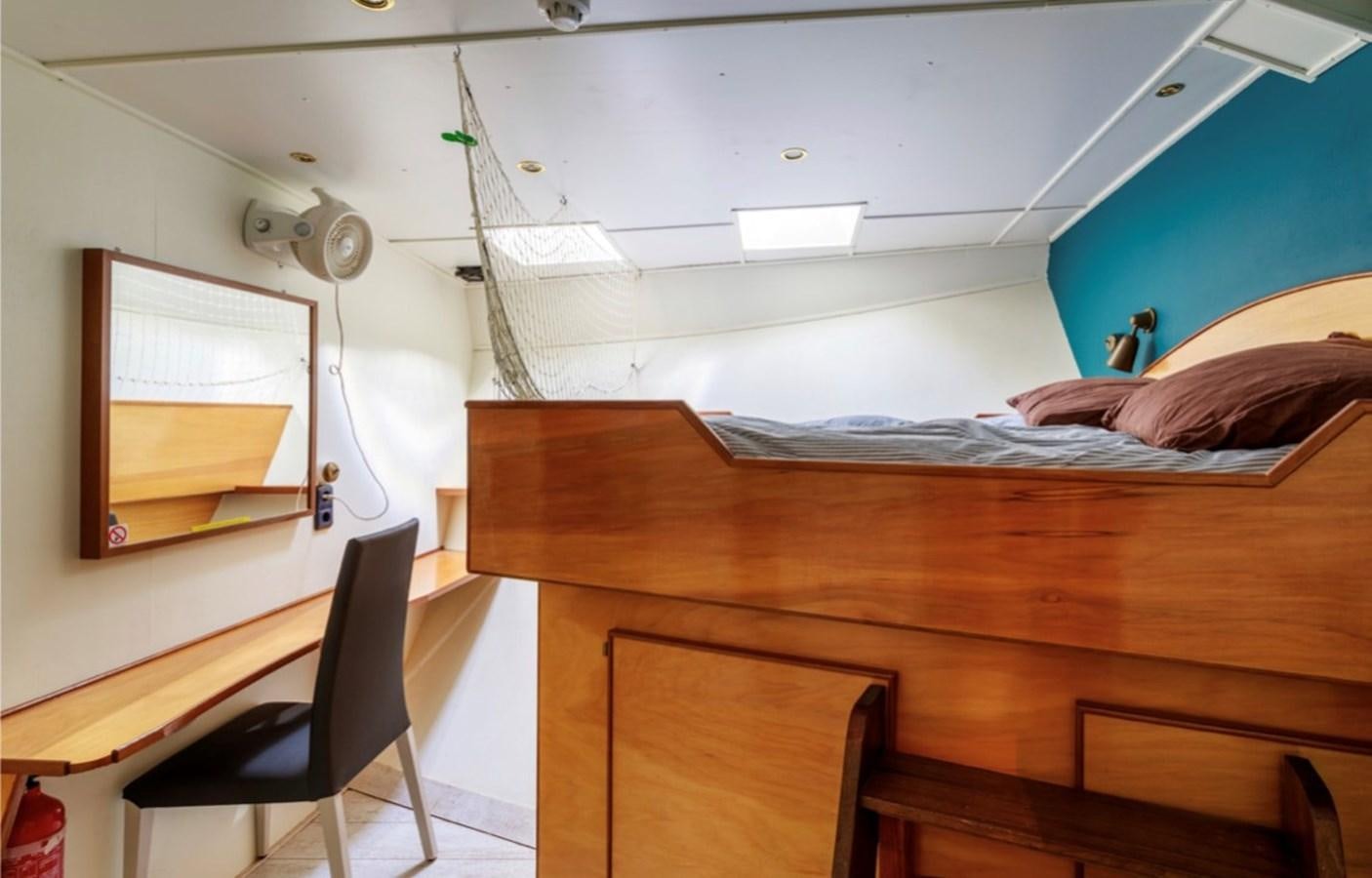 a bedroom with a bed and a desk aboard FAMILY Yacht for Sale