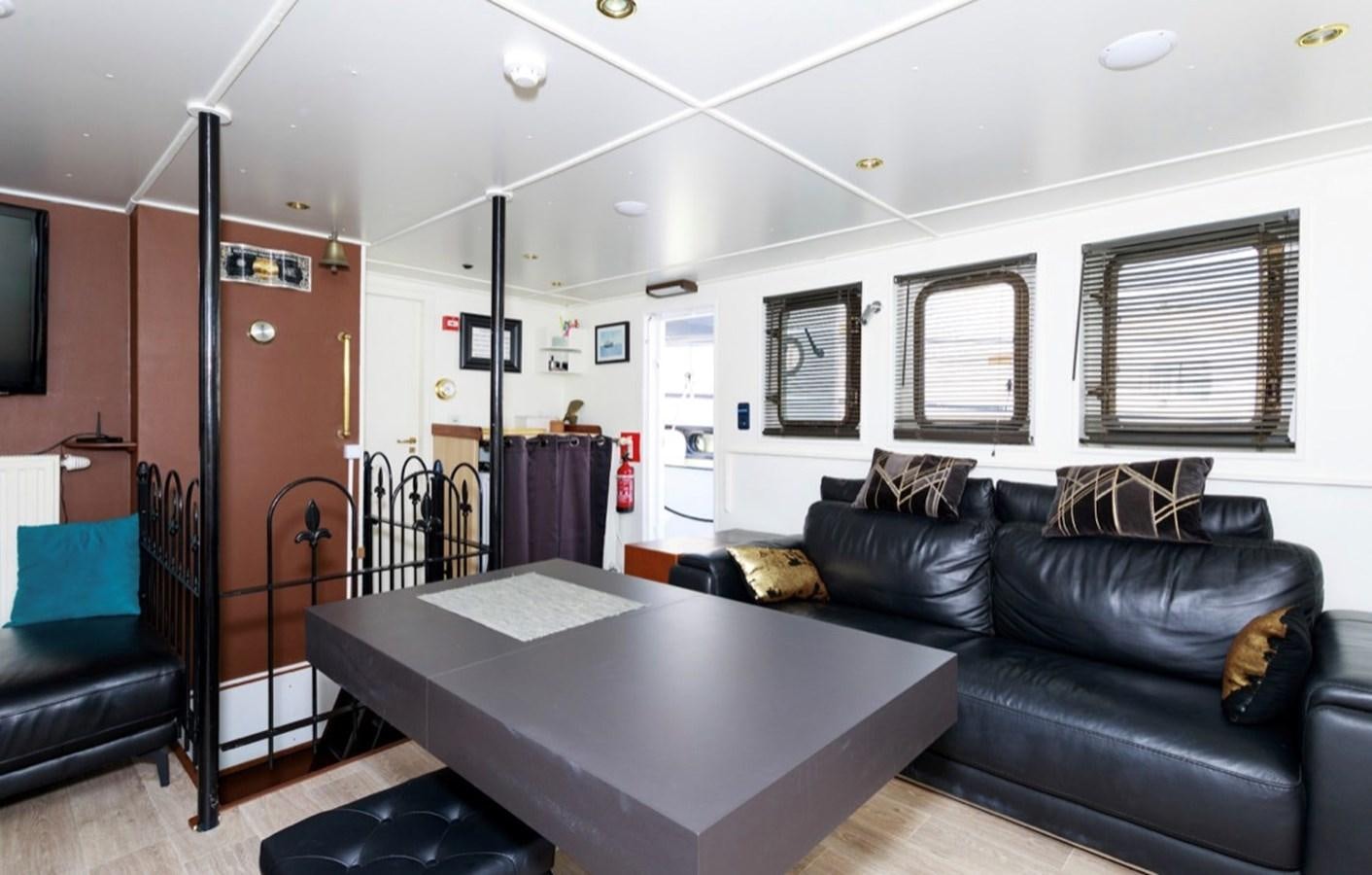a living room with a black couch and a black coffee table aboard FAMILY Yacht for Sale