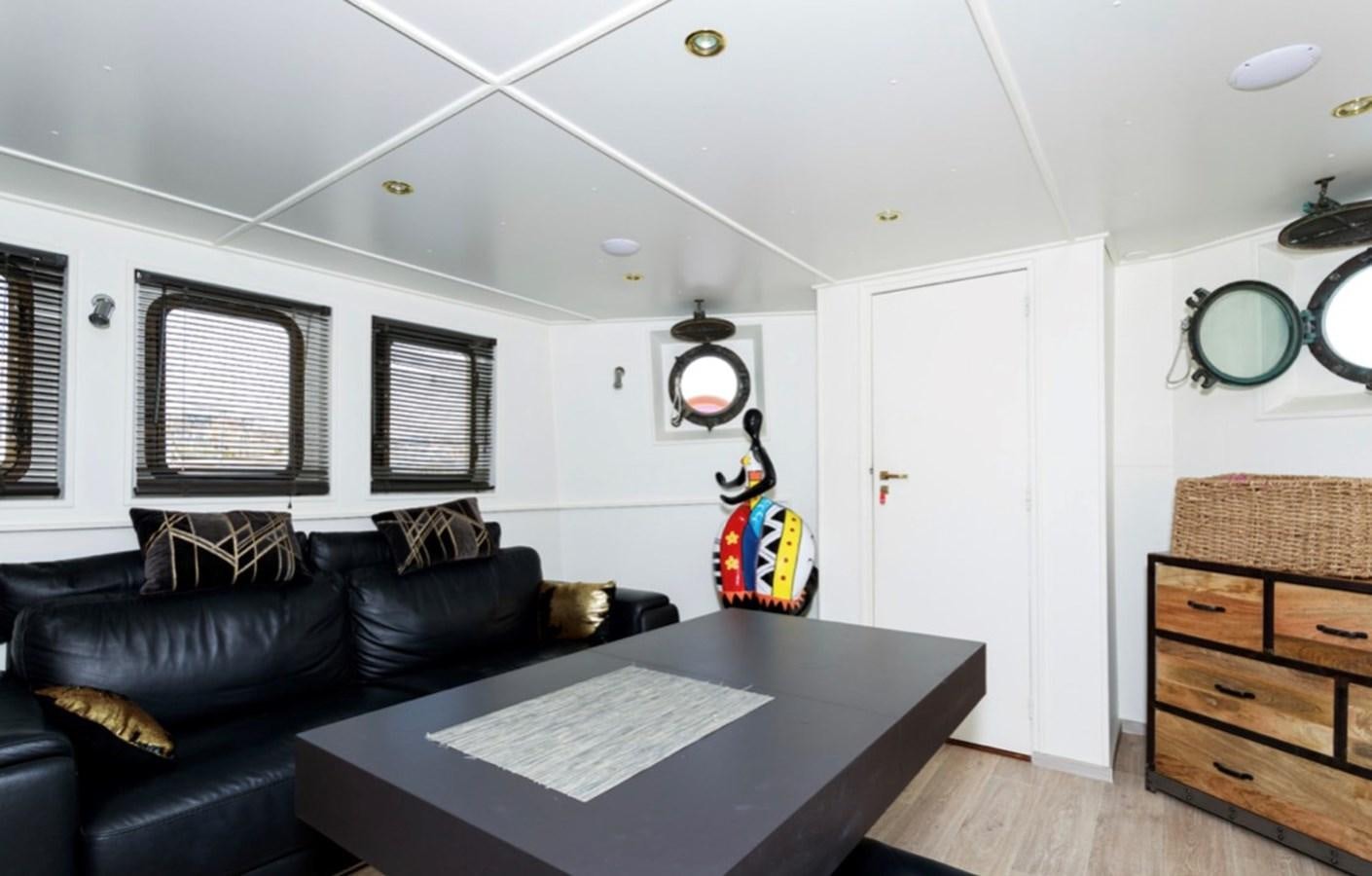a living room with a black couch and a black leather couch aboard FAMILY Yacht for Sale