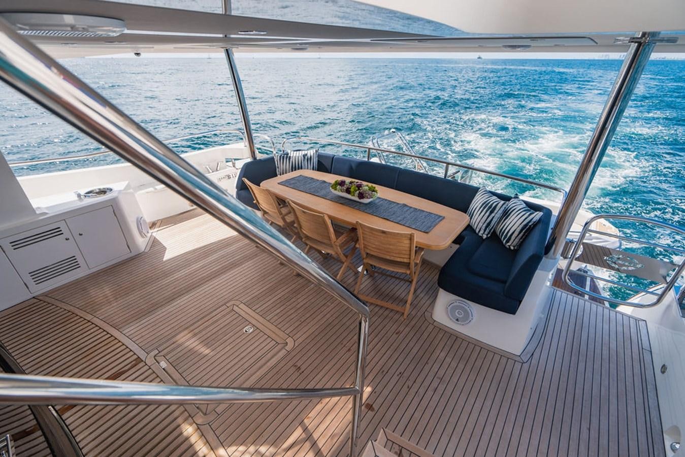 a deck with a table and chairs on it aboard GALLIVANT Yacht for Sale