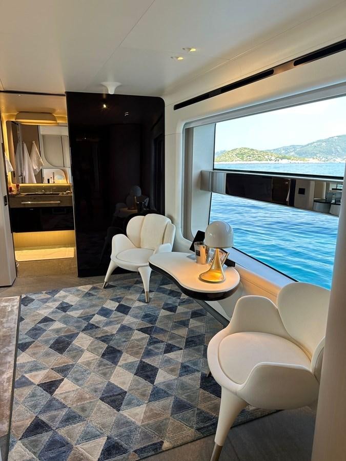a room with a table chairs and a bed aboard NG Yacht for Sale