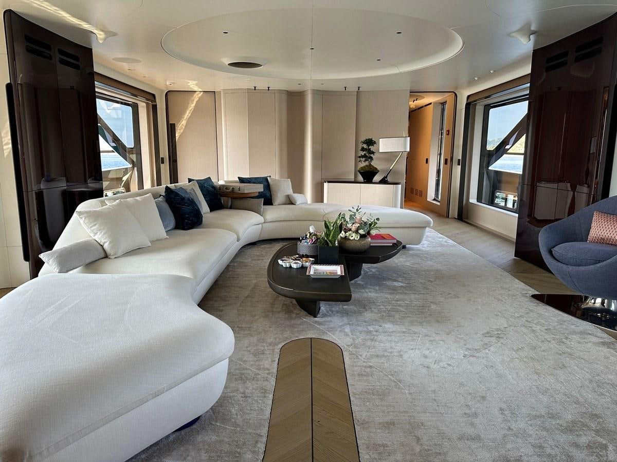 a large living room with white couches and a coffee table aboard NG Yacht for Sale