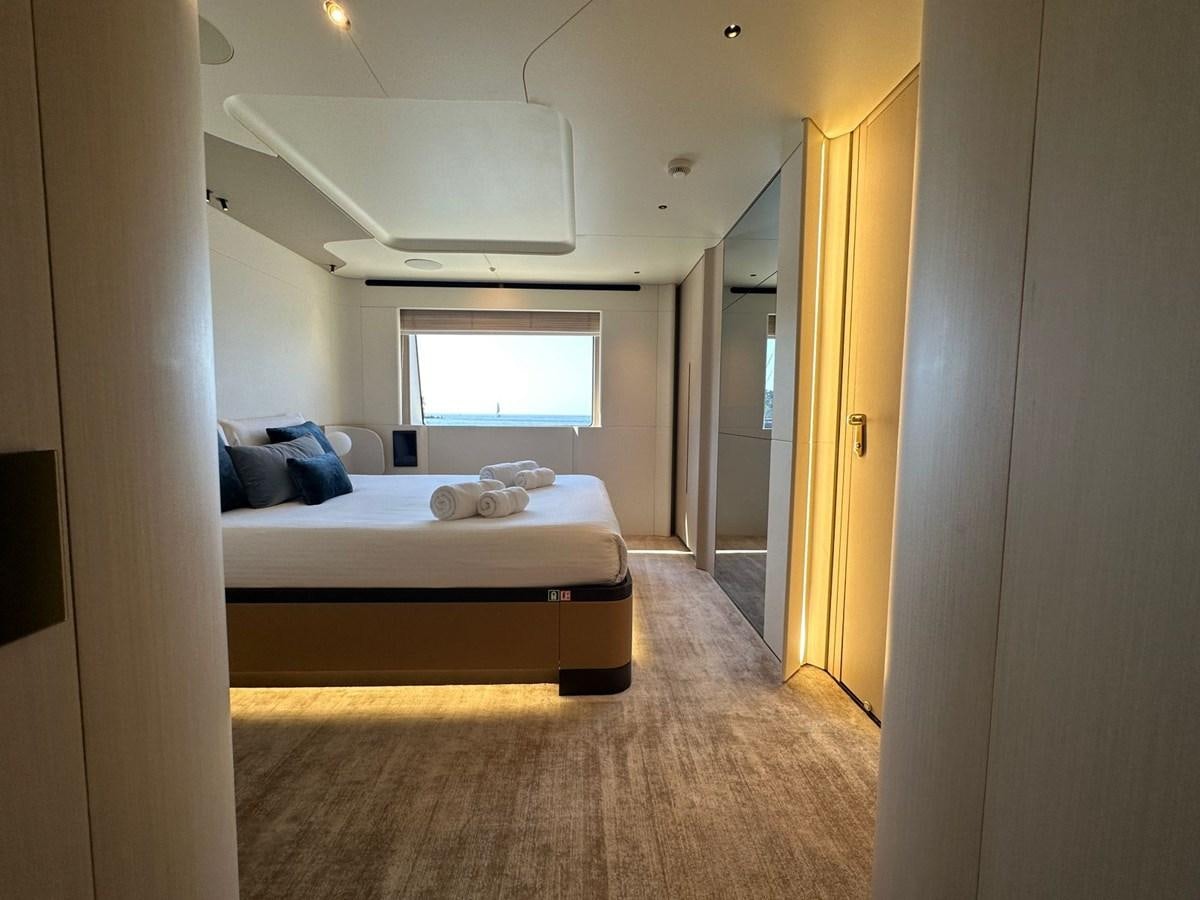 a bedroom with a bed and a window aboard NG Yacht for Sale