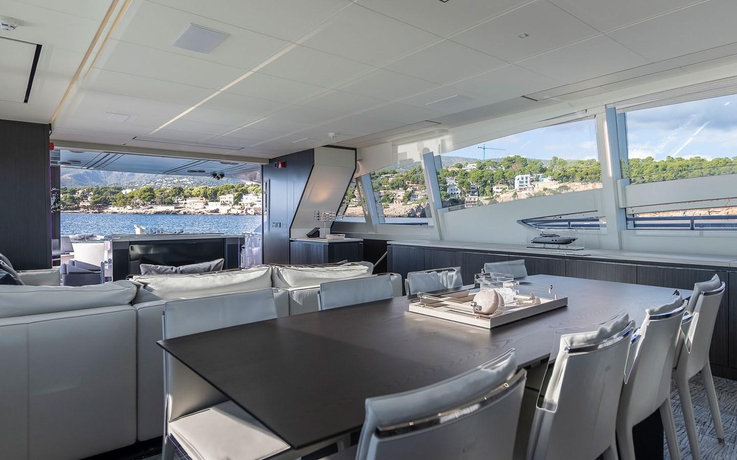 a large open space with a large table and chairs and a large window aboard ALDEBARAN III Yacht for Sale