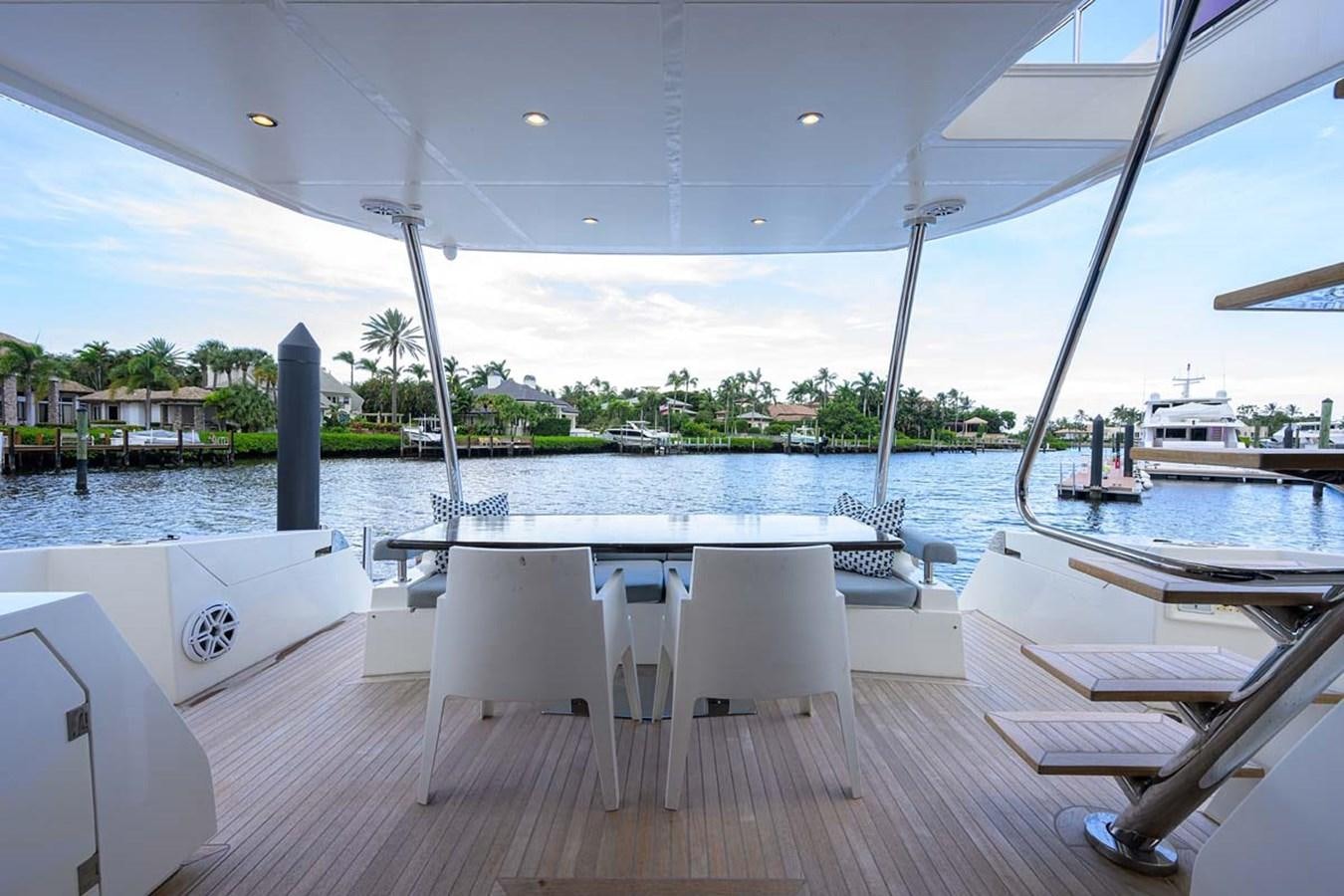 a deck with a table and chairs on it aboard XHALE Yacht for Sale