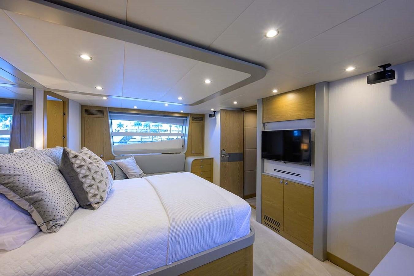 a bedroom with a bed and a tv aboard XHALE Yacht for Sale