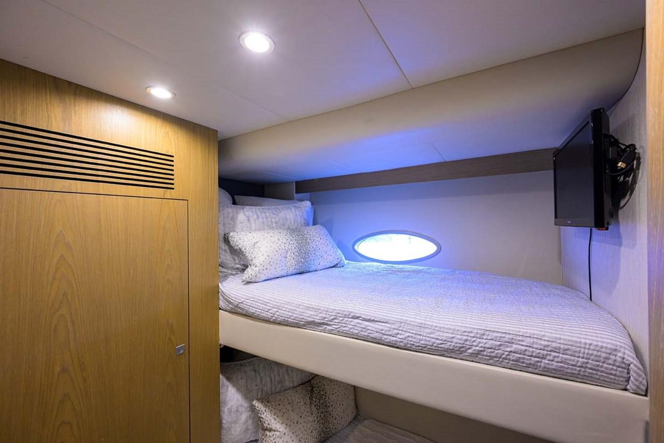a bed with a television on the wall aboard XHALE Yacht for Sale