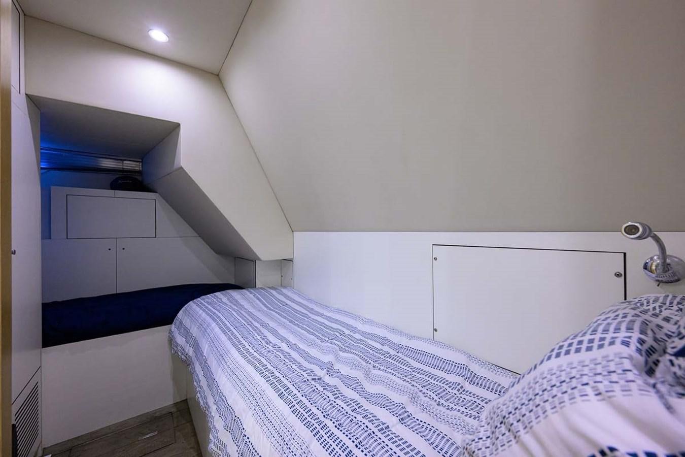 a room with a bed and a white wall aboard XHALE Yacht for Sale