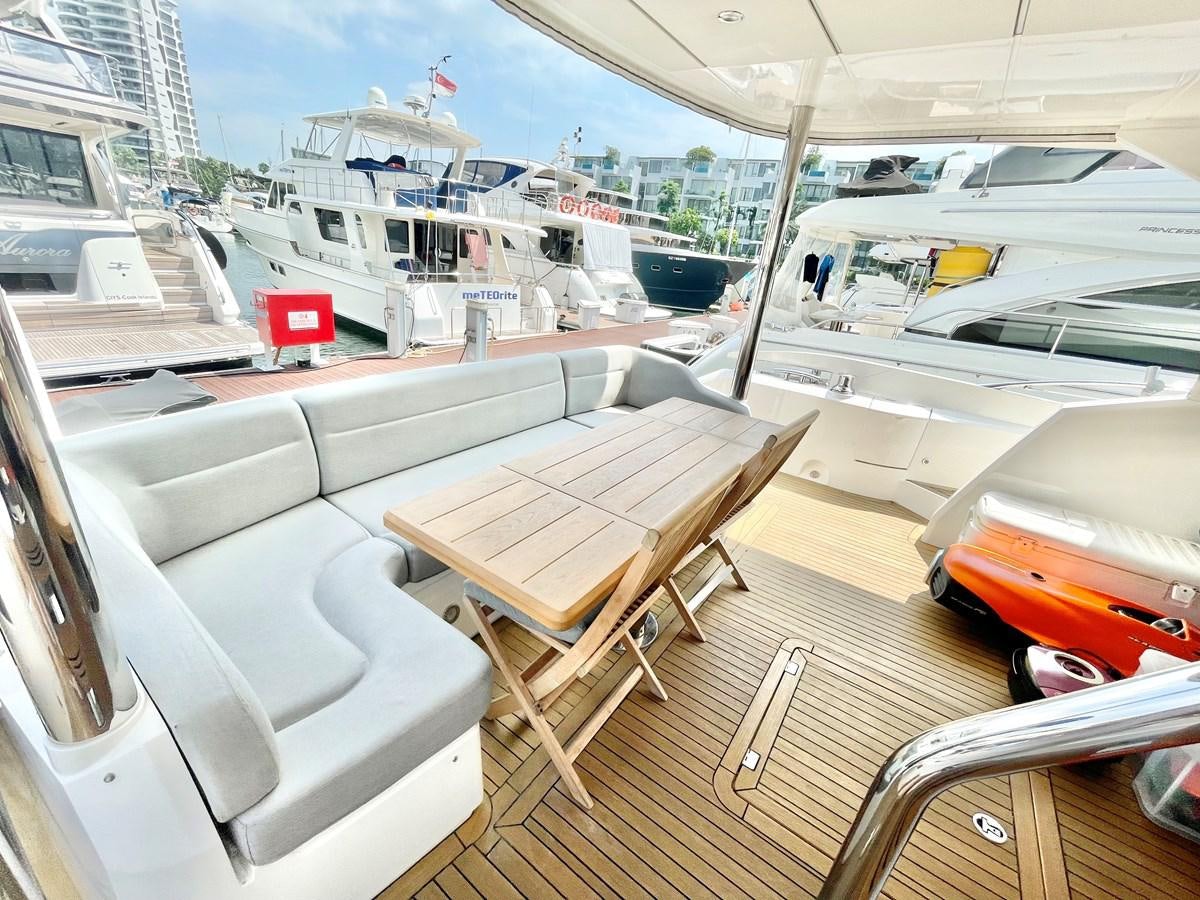 a boat deck with a table and chairs on it aboard EXCELLENCE Yacht for Sale