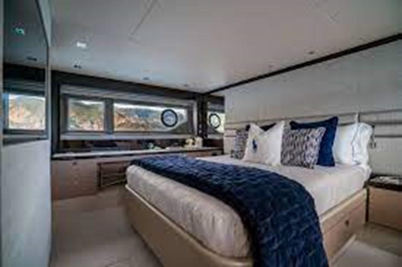 a bedroom with a bed and a large window aboard EXCELLENCE Yacht for Sale