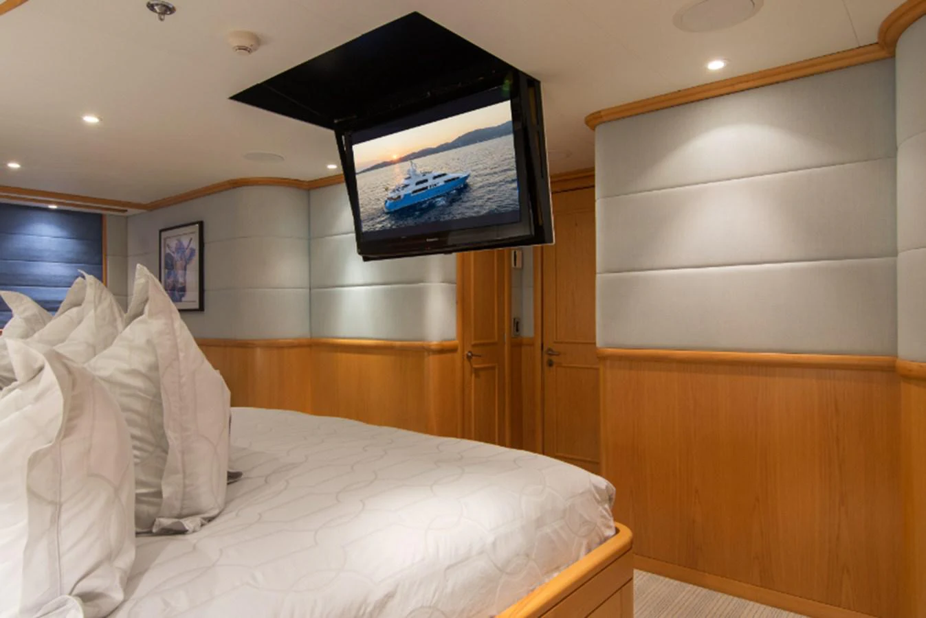 a bed with a television on the wall aboard 4*PUPPIES Yacht for Sale