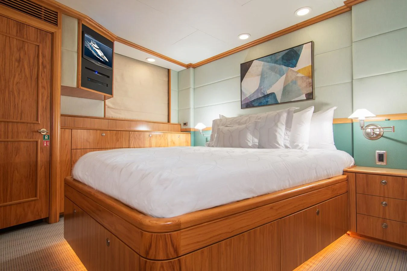 a bed with a television on the wall aboard 4*PUPPIES Yacht for Sale