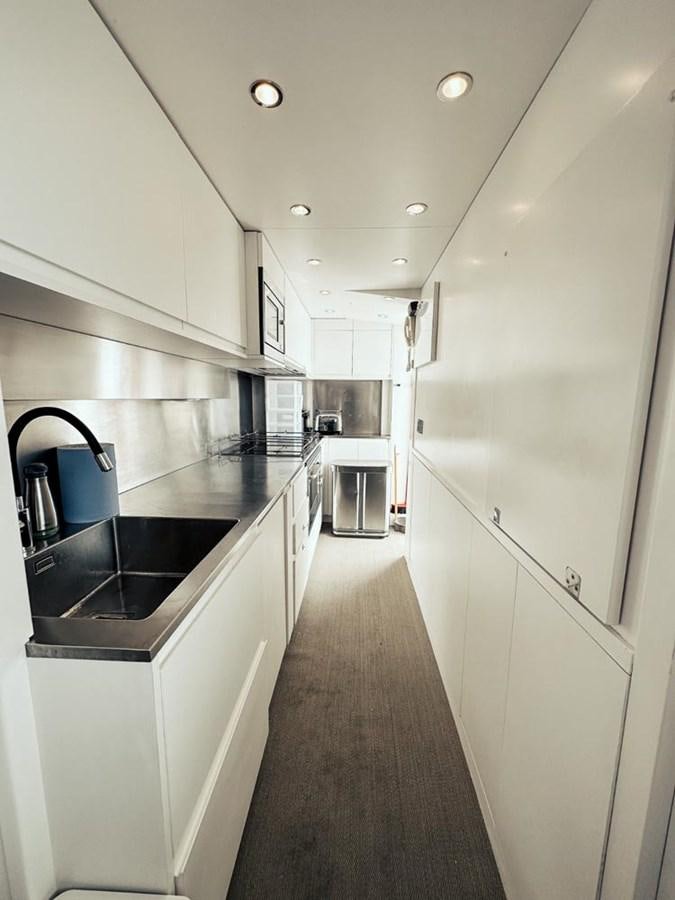 a kitchen with white cabinets aboard LAZIZA Yacht for Sale