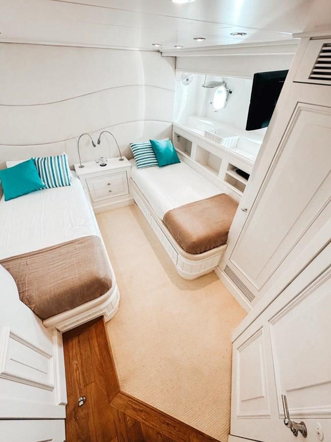 a small white room with a bed and a chair aboard LAZIZA Yacht for Sale