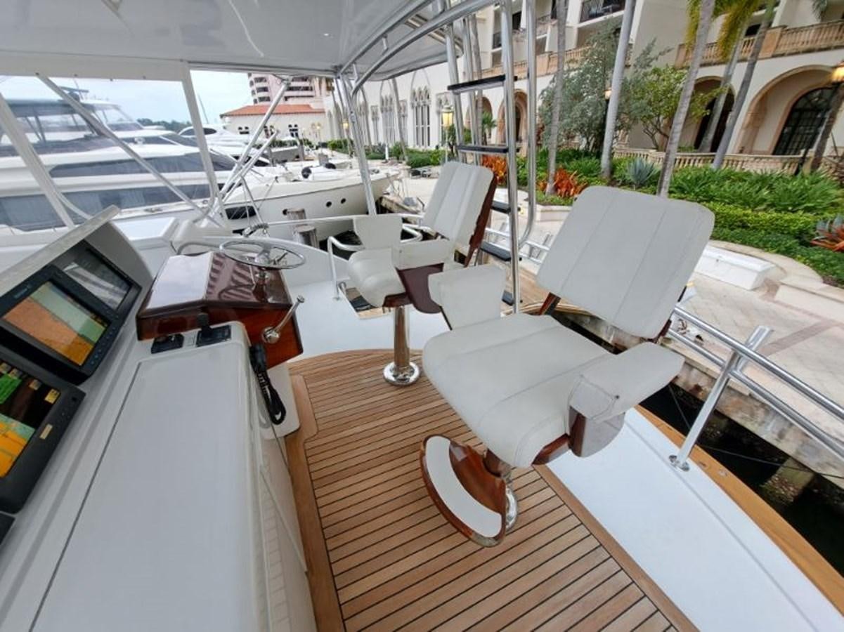 a room with a table chairs and a boat in the water aboard CLAIRE TOO Yacht for Sale