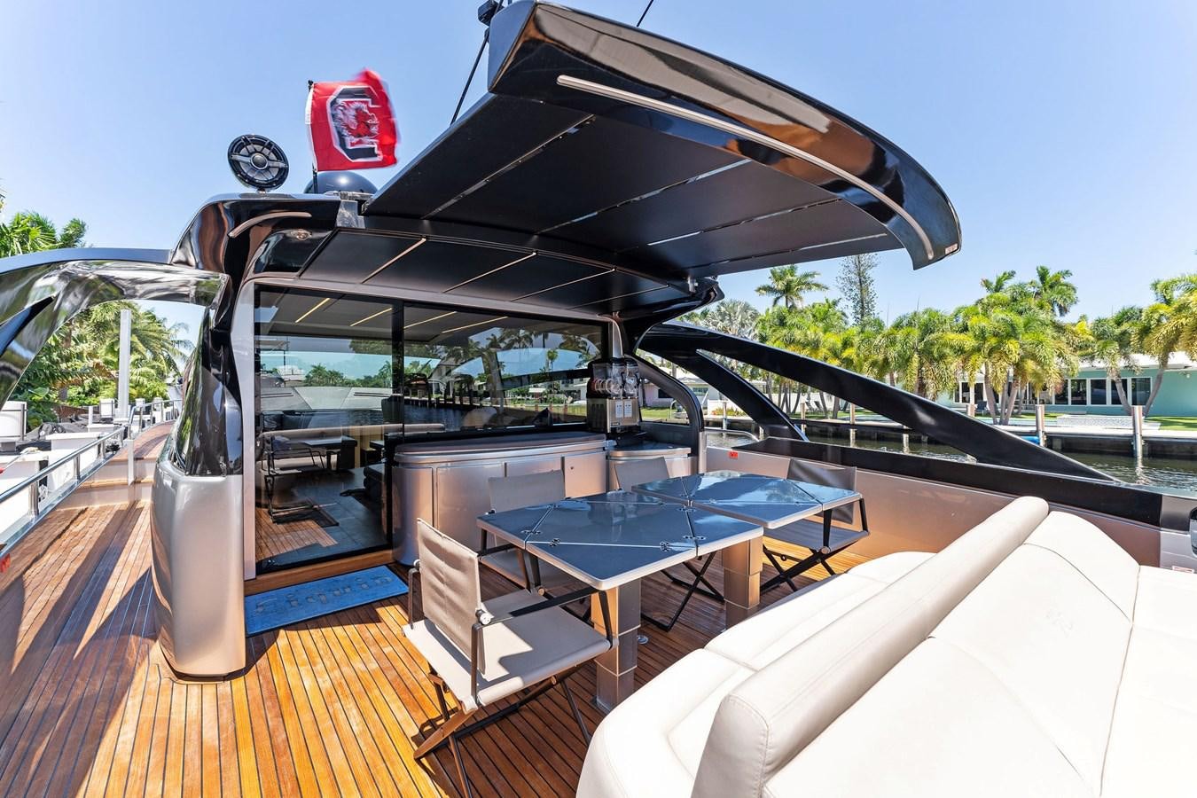 a covered patio with a table and chairs on a deck aboard LIQUID Yacht for Sale