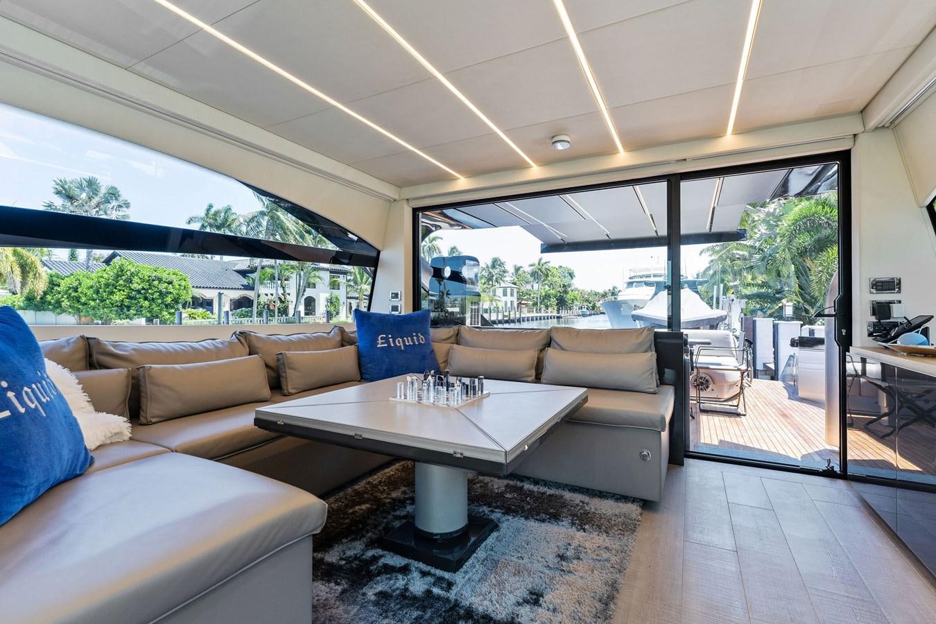 a living room with a table and couches aboard LIQUID Yacht for Sale