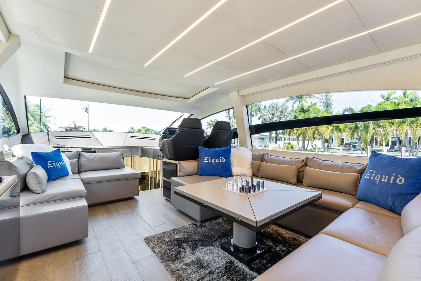 a living room with couches and a table aboard LIQUID Yacht for Sale