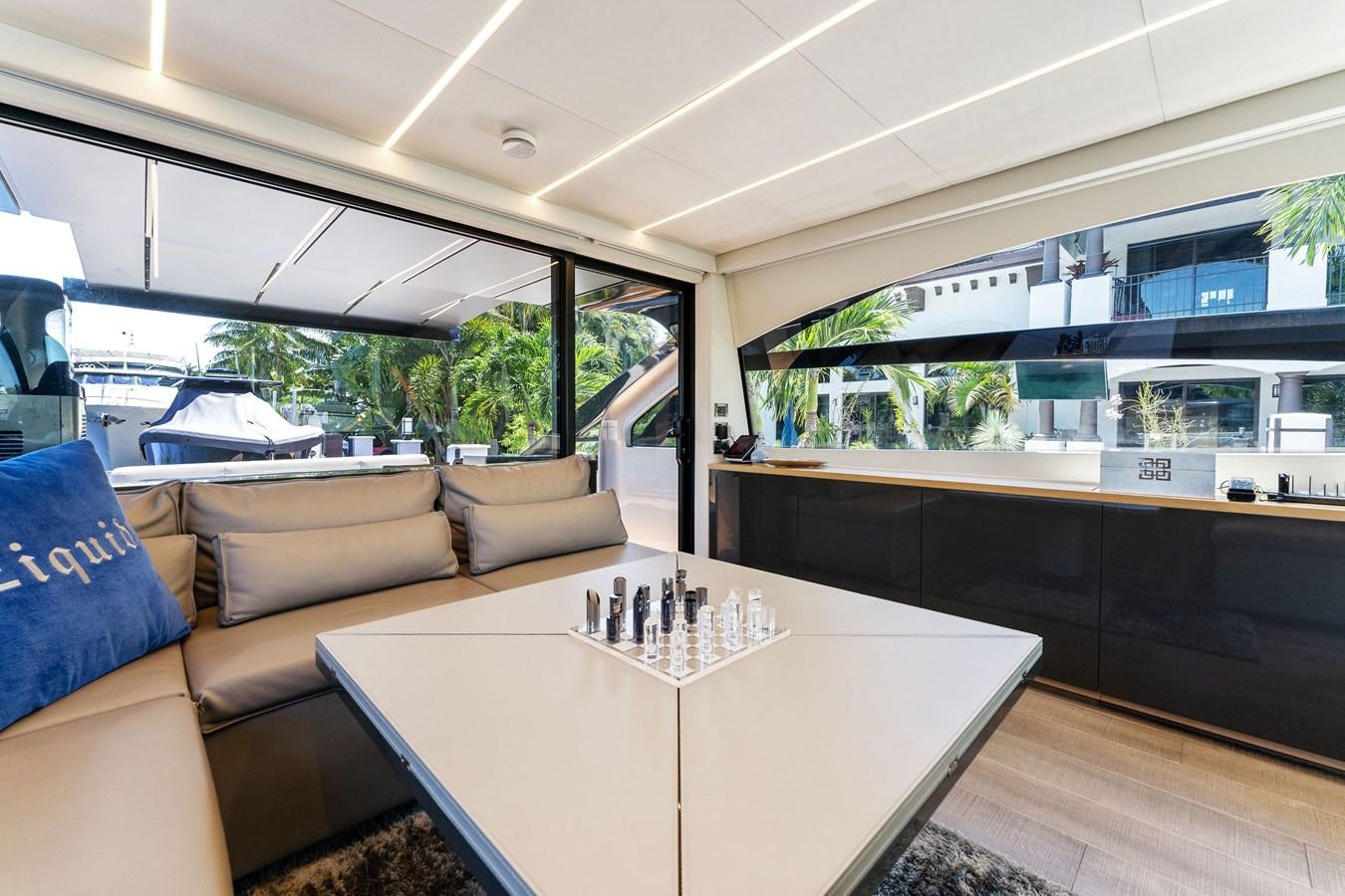 a living room with a table and couches aboard LIQUID Yacht for Sale