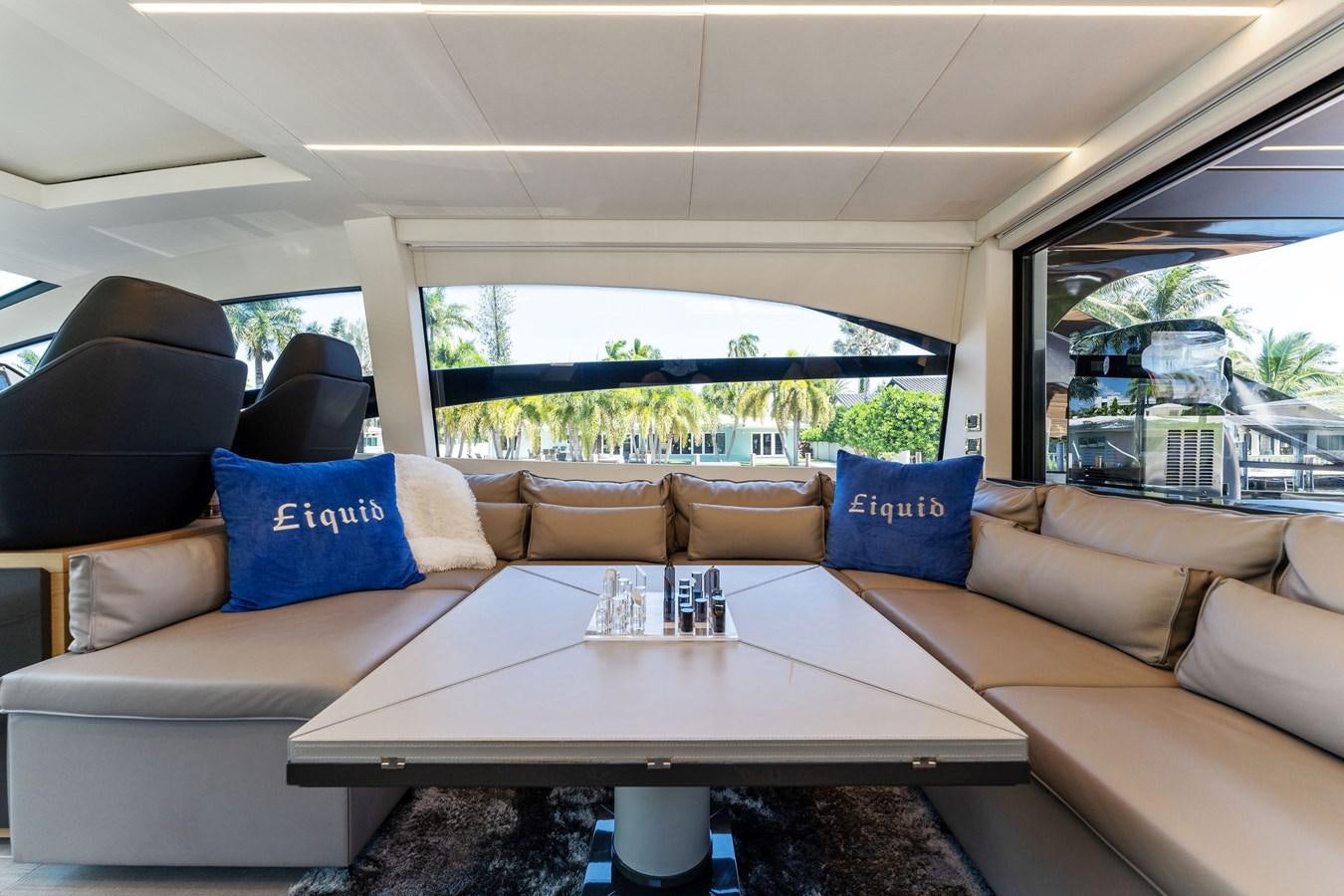 a living room with a couch and a table aboard LIQUID Yacht for Sale