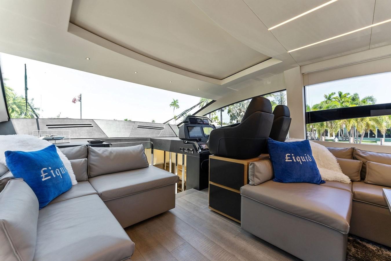 a living room with couches and a large window aboard LIQUID Yacht for Sale