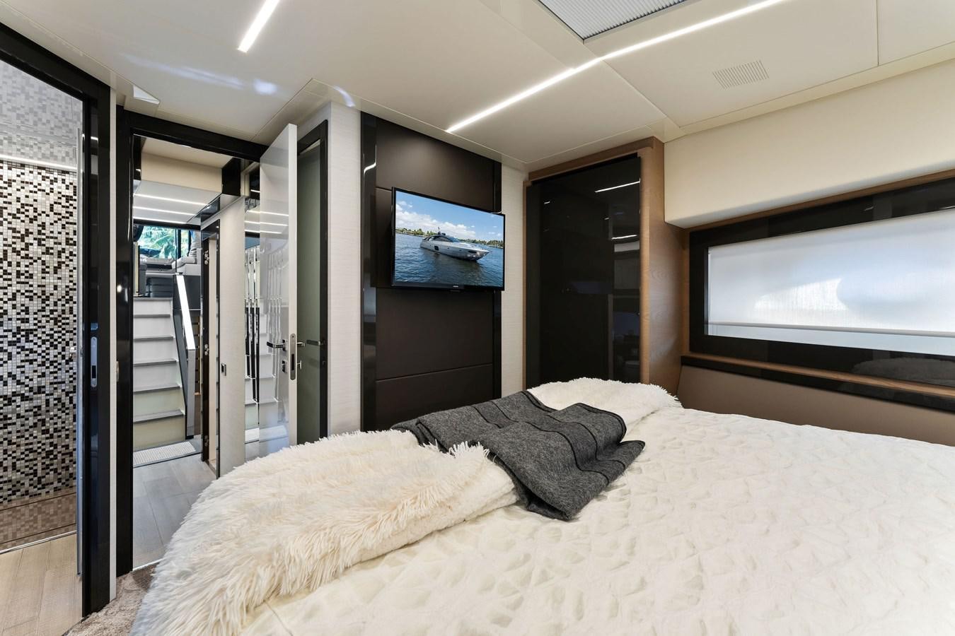 a bed with a television on the wall aboard LIQUID Yacht for Sale