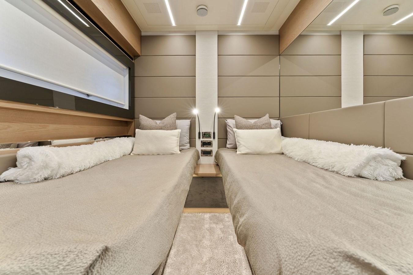 a room with a couple of beds aboard LIQUID Yacht for Sale