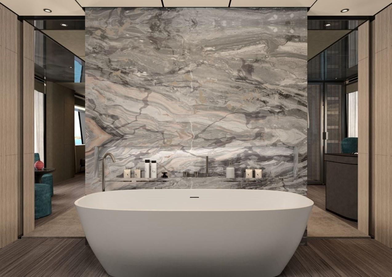 a large white bathtub in a room with a large stone wall aboard AMARE Yacht for Sale