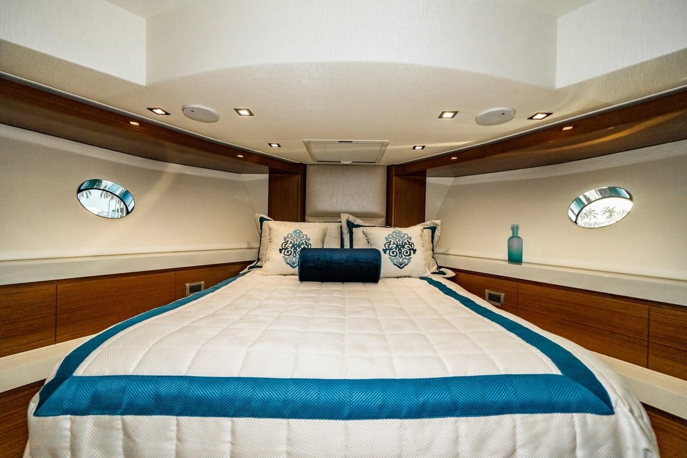 a room with a bed and a blue and white bed aboard 2017 HATTERAS M75 K SEA Yacht for Sale
