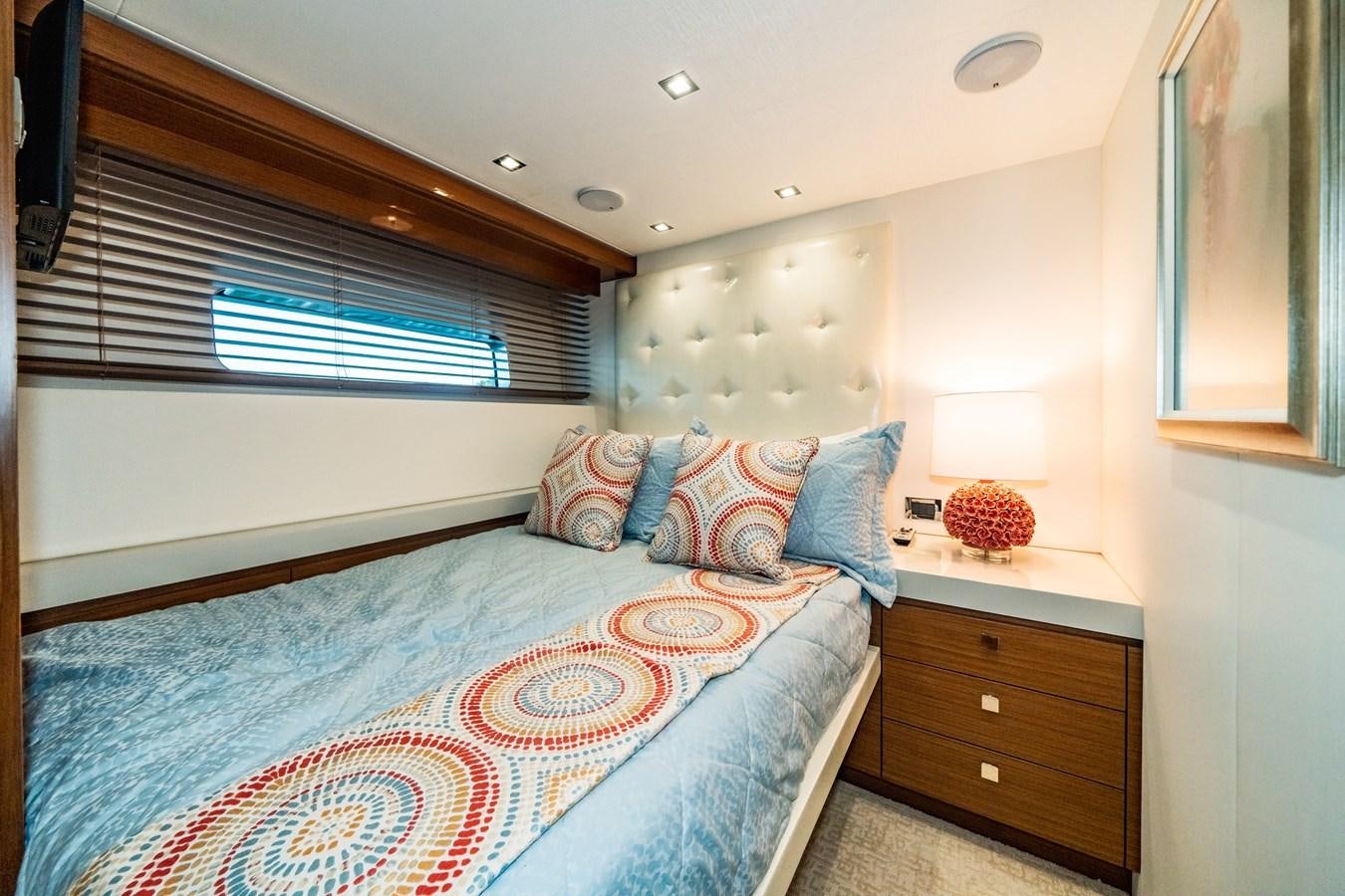 a bedroom with a bed and a window aboard 2017 HATTERAS M75 K SEA Yacht for Sale