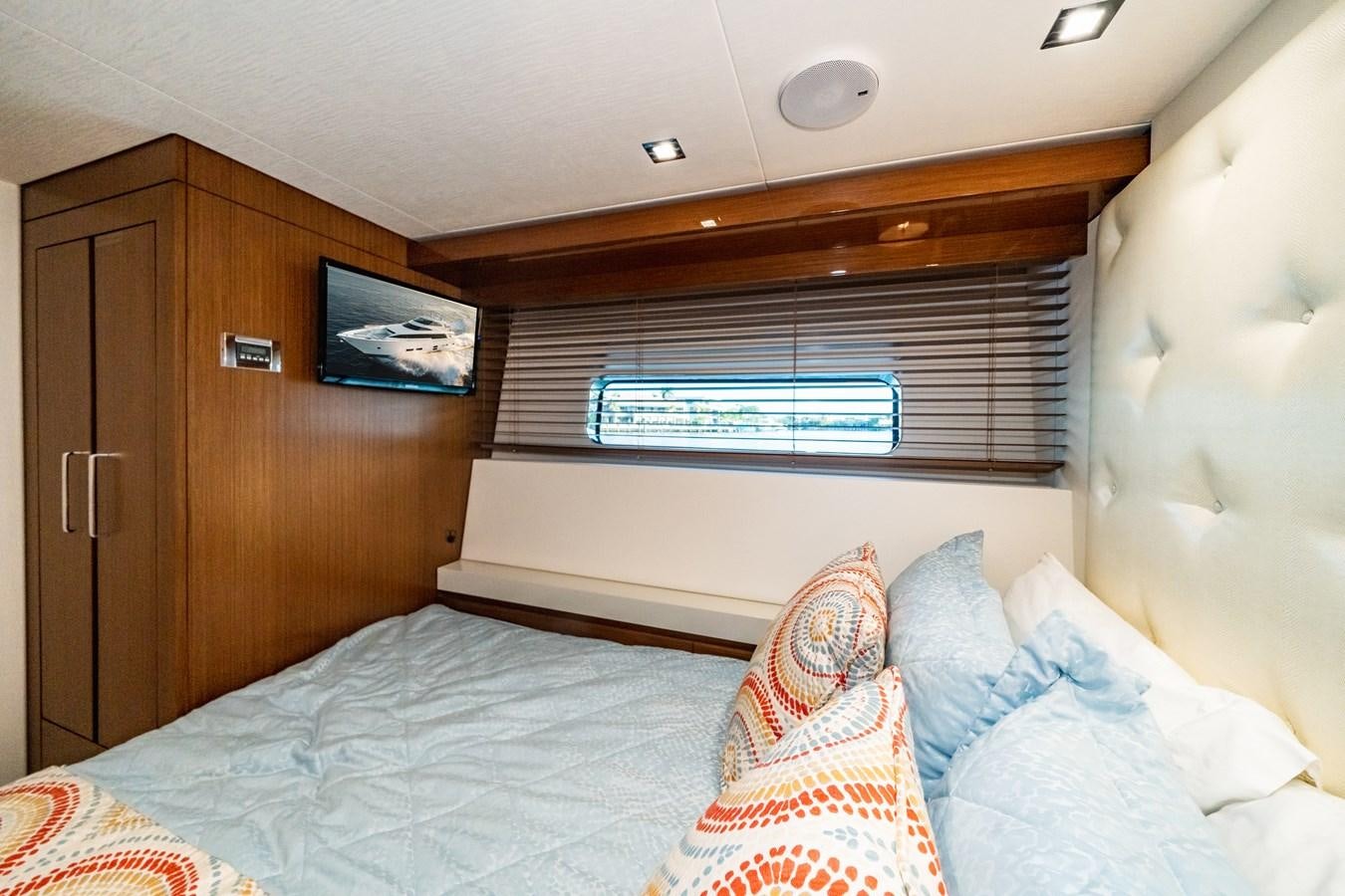 a bed with pillows and a television aboard 2017 HATTERAS M75 K SEA Yacht for Sale