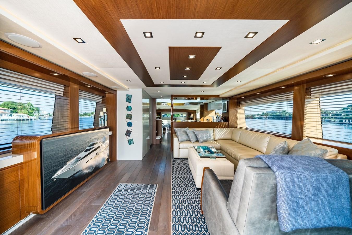 a living room with a large screen aboard 2017 HATTERAS M75 K SEA Yacht for Sale